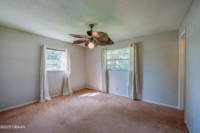 unfurnished room featuring ceiling fan, light colored carpet, and a textured ceiling