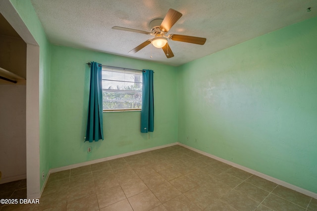 empty room with ceiling fan and a textured ceiling