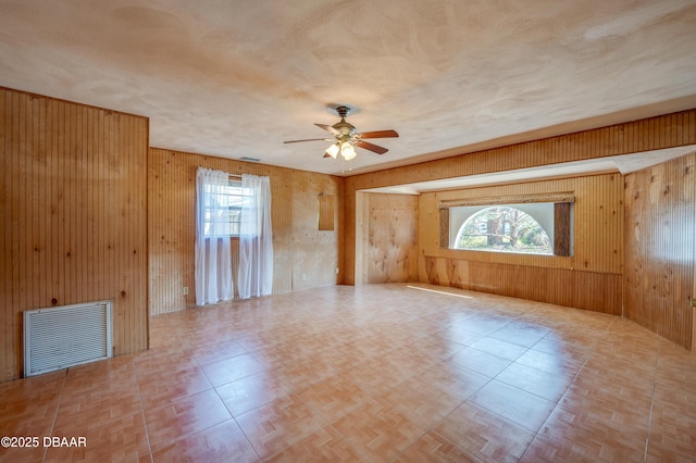 spare room with plenty of natural light and wood walls