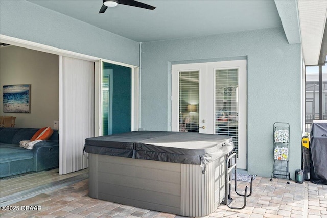 view of patio with ceiling fan and a hot tub