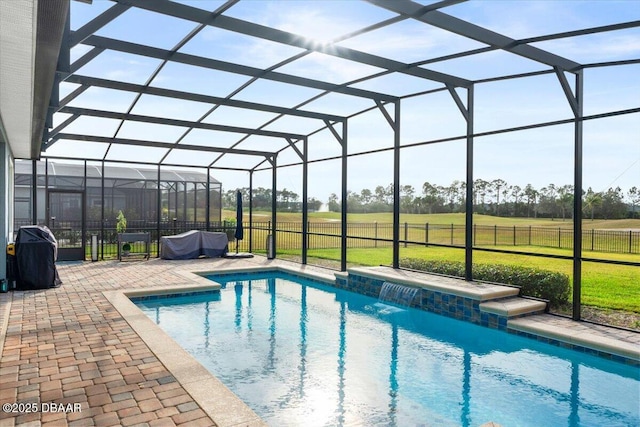 view of pool with glass enclosure, a yard, a patio area, and area for grilling