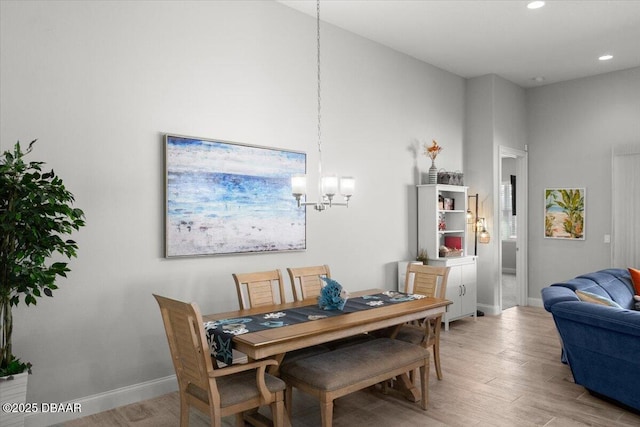 dining space with a notable chandelier and light hardwood / wood-style flooring