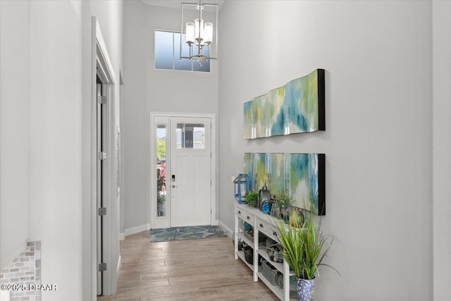 entrance foyer with wood-type flooring and an inviting chandelier