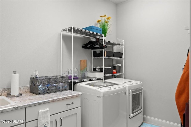 laundry room featuring cabinets and washer and clothes dryer