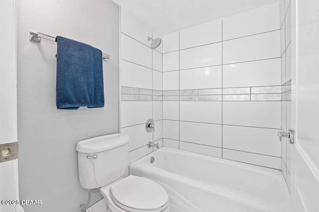 bathroom featuring tub / shower combination and toilet