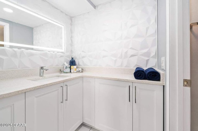 interior space with white cabinetry, light stone countertops, and a sink