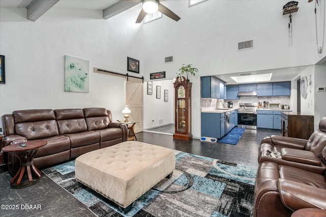 living room with a barn door, a high ceiling, ceiling fan, beam ceiling, and sink