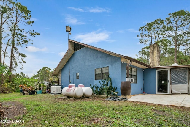 back of house featuring a lawn and a patio area