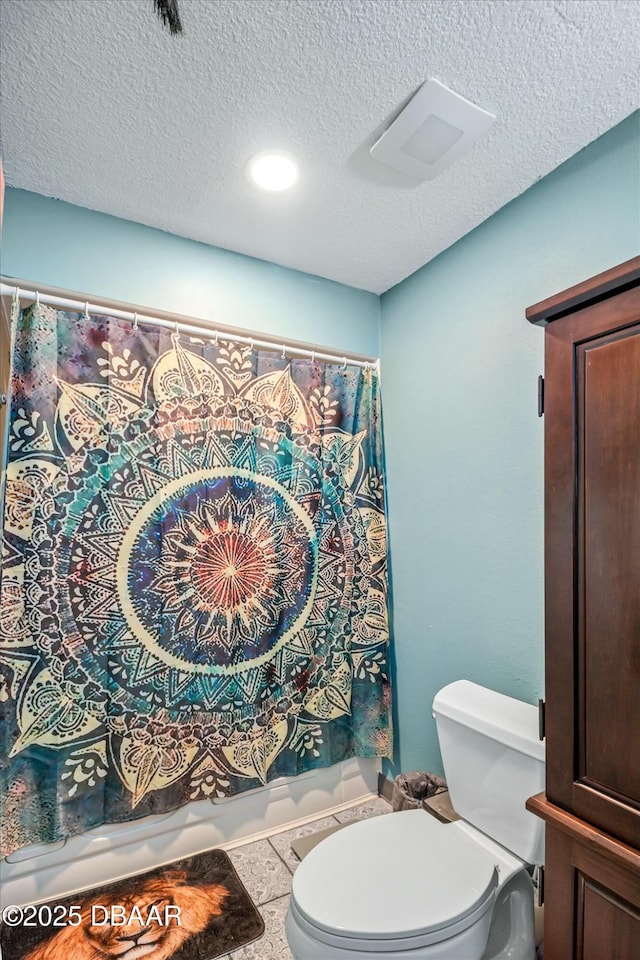 bathroom featuring a textured ceiling and toilet