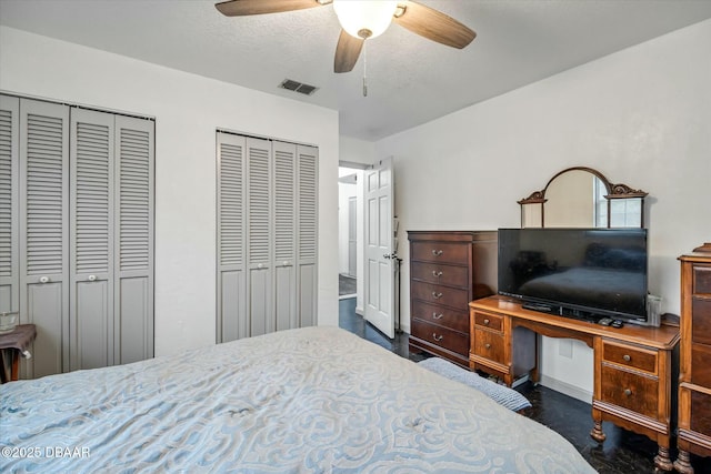 bedroom with multiple closets and ceiling fan