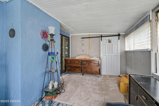 interior space with a barn door and light carpet