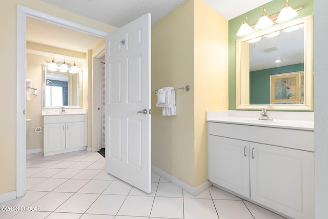 bathroom featuring toilet, vanity, a textured ceiling, and tile patterned flooring