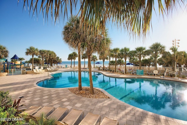 view of swimming pool with a patio and a water view