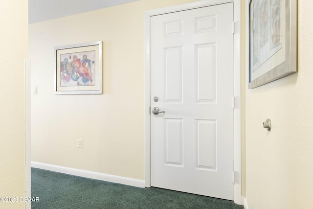 hallway featuring dark colored carpet