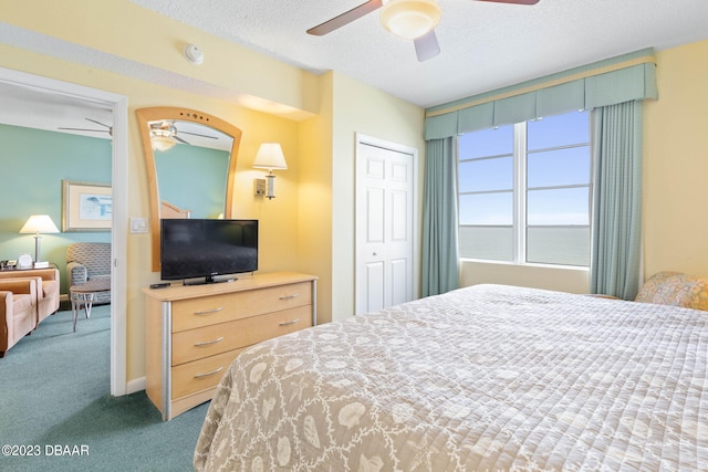 carpeted bedroom featuring a closet, a textured ceiling, and ceiling fan