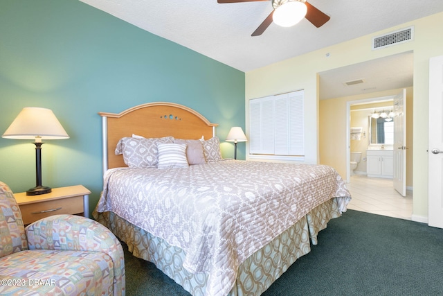 carpeted bedroom with ceiling fan and ensuite bathroom