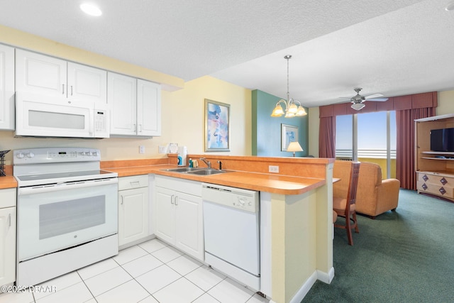 kitchen with white appliances, sink, decorative light fixtures, and kitchen peninsula