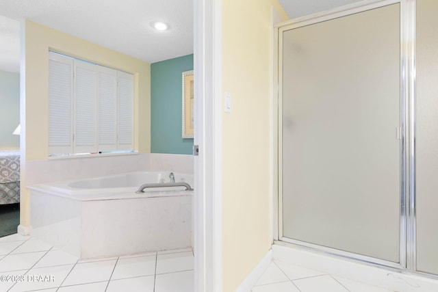 bathroom featuring a textured ceiling, tile patterned flooring, and separate shower and tub