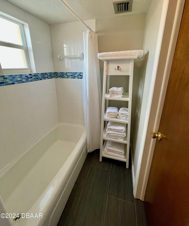 bathroom with shower / tub combo, a textured ceiling, and wood-type flooring