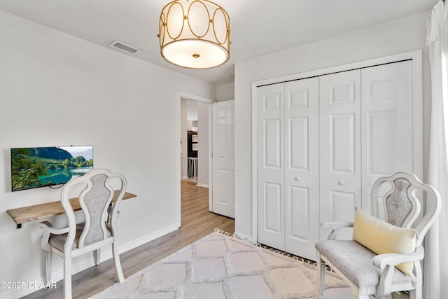 sitting room with visible vents, baseboards, and light wood-style floors