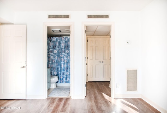 unfurnished bedroom featuring light hardwood / wood-style flooring and ensuite bath