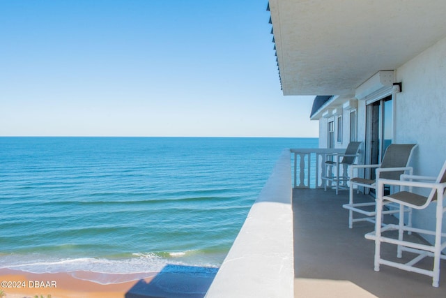 balcony featuring a water view and a beach view