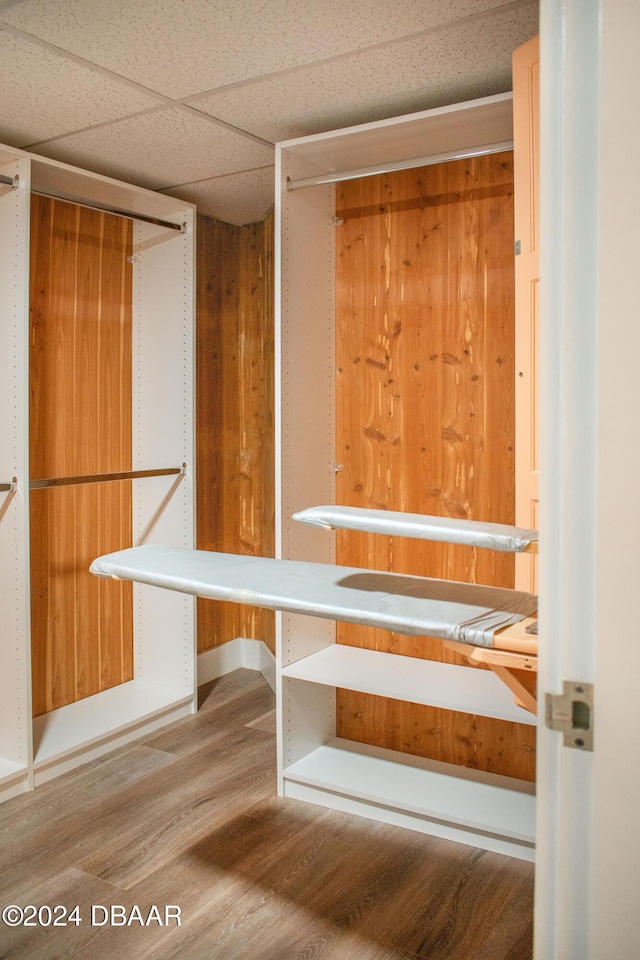 interior space with a drop ceiling and hardwood / wood-style floors