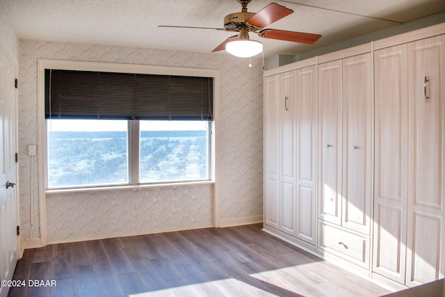 unfurnished bedroom with ceiling fan, two closets, and light wood-type flooring