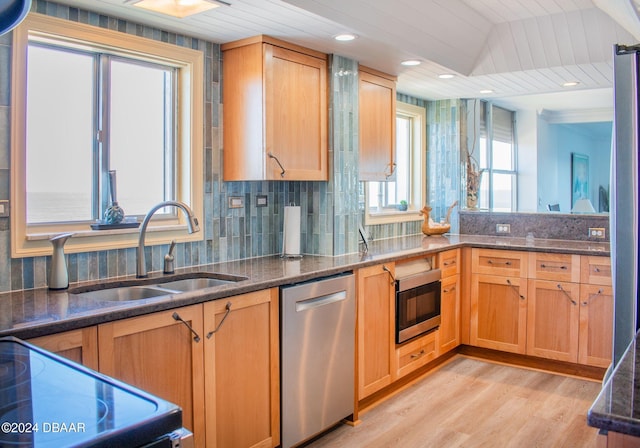 kitchen featuring stove, stainless steel dishwasher, vaulted ceiling, sink, and light hardwood / wood-style floors