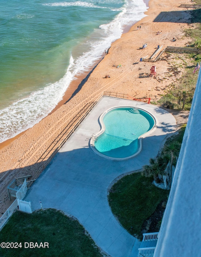 view of pool featuring a beach view and a water view