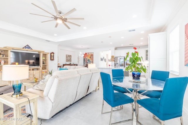 living room featuring ornamental molding, a tray ceiling, and ceiling fan