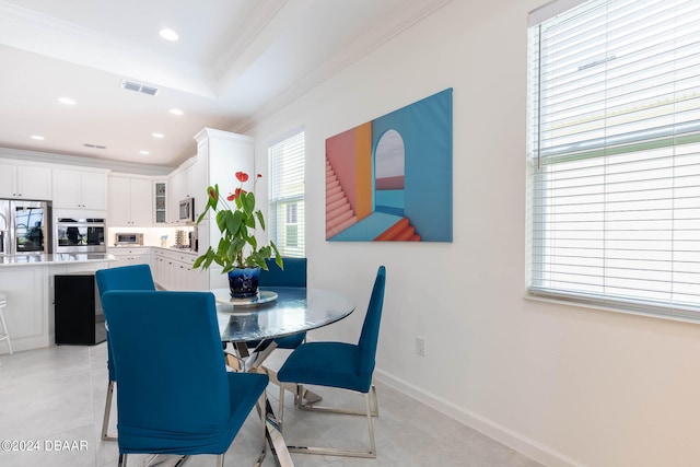 dining room with ornamental molding and light tile patterned floors