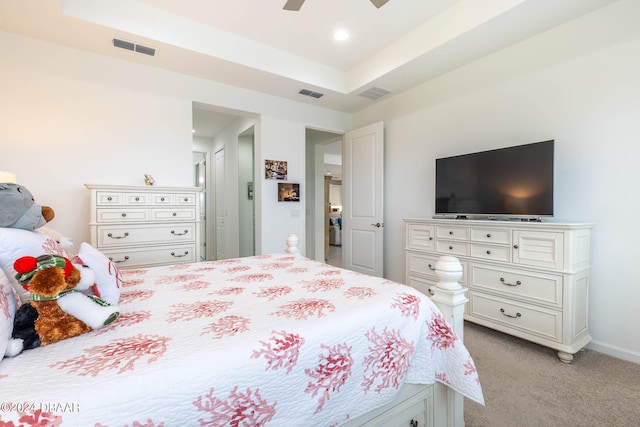 bedroom with light colored carpet, ceiling fan, and a raised ceiling