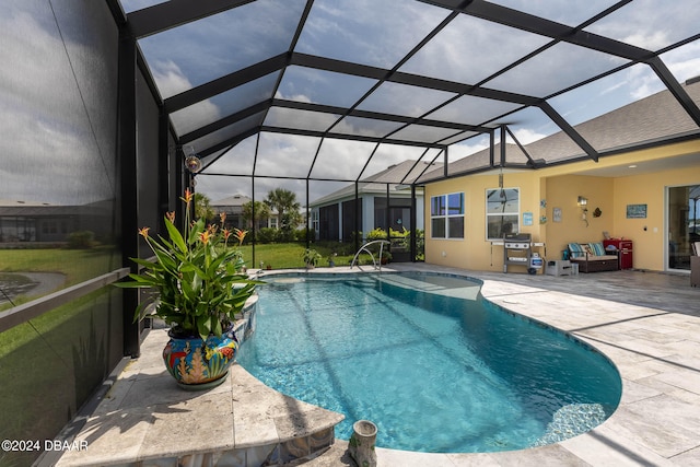 view of pool with glass enclosure and a patio area