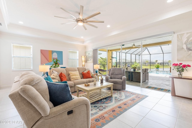 tiled living room with plenty of natural light, ceiling fan, and a tray ceiling