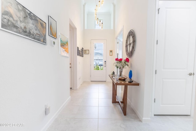 entryway featuring light tile patterned floors and an inviting chandelier