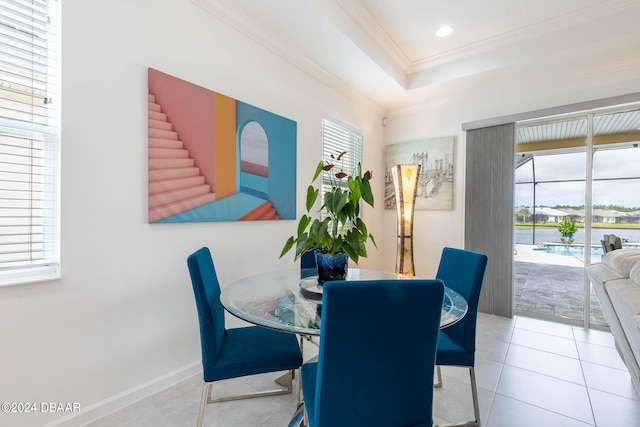 dining room with light tile patterned floors and crown molding