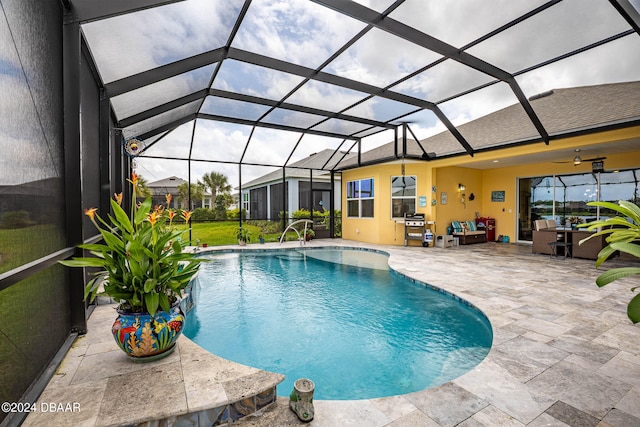 view of swimming pool with a lanai, ceiling fan, and a patio area