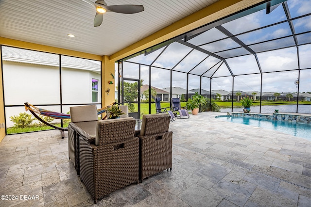 view of patio / terrace featuring glass enclosure, a water view, ceiling fan, and pool water feature