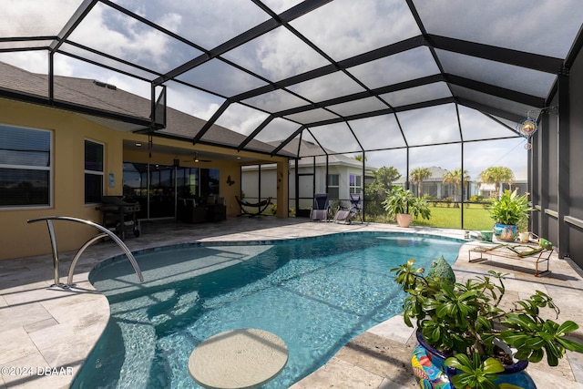 view of swimming pool with ceiling fan, a lanai, and a patio area