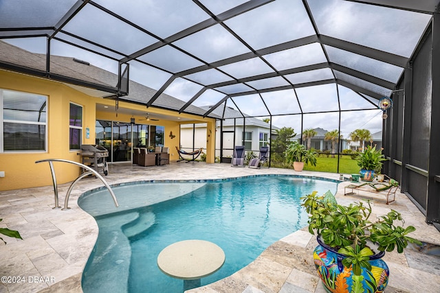 view of swimming pool with ceiling fan, a lanai, and a patio area