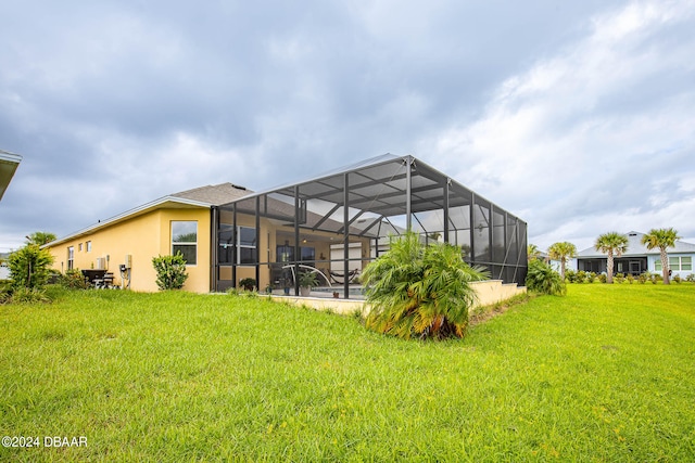 back of house with glass enclosure and a lawn