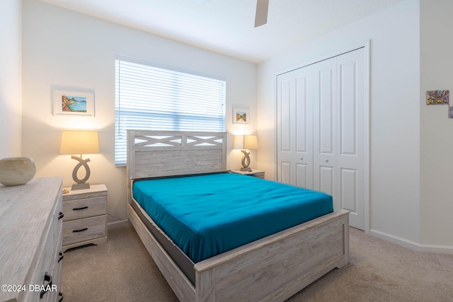 carpeted bedroom with ceiling fan and a closet