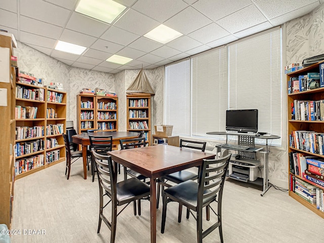 dining room featuring a drop ceiling and light carpet