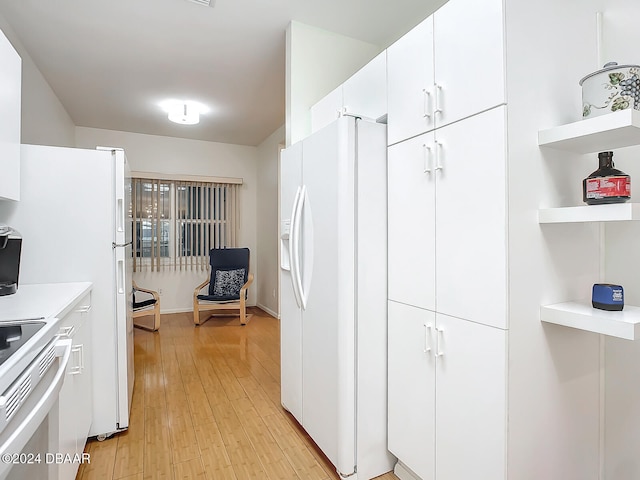 kitchen featuring white fridge with ice dispenser, range, light hardwood / wood-style floors, and white cabinets