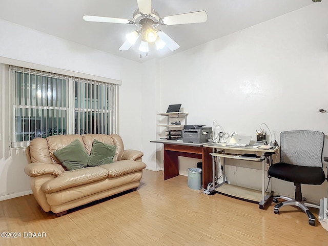 office with light wood-type flooring and ceiling fan