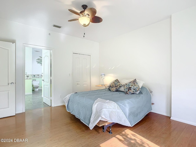 4 Oceans W Blvd Unit 108B, Daytona Beach Shores, FL 32118 - bedroom featuring wood finished floors, ensuite bath, a closet, and a ceiling fan