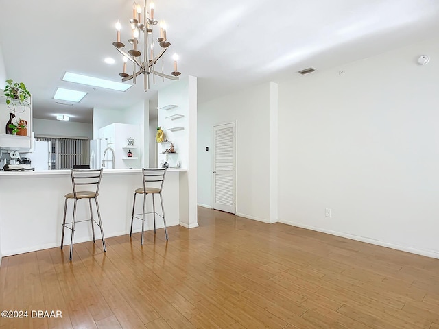 4 Oceans W Blvd Unit 108B, Daytona Beach Shores, FL 32118 - dining area with wood finished floors, a chandelier, a skylight, and baseboards