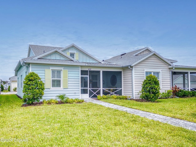452 Lime Ave, Daytona Beach, FL 32124 - ranch-style house with roof with shingles, a sunroom, and a front yard