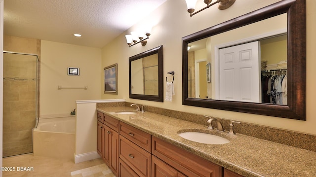 bathroom with separate shower and tub, vanity, tile patterned floors, and a textured ceiling